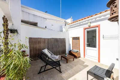 a patio with a black chair and a table at Townhouse N7 - Albufeira in Albufeira