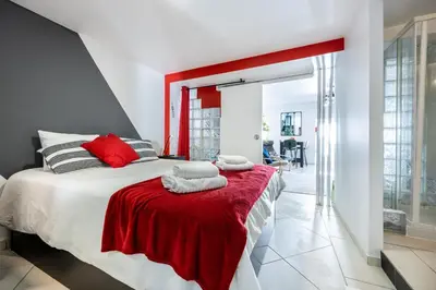 a bedroom with a red and white bed with towels on it at Townhouse N7 - Albufeira in Albufeira