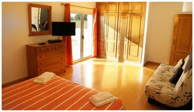 a bedroom with a bed and a dresser and a mirror at Casa do Mar by Laranjal Rentals in Albufeira