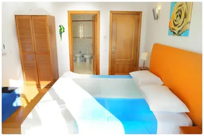 a bedroom with a bed and a bathroom at Casa do Mar by Laranjal Rentals in Albufeira