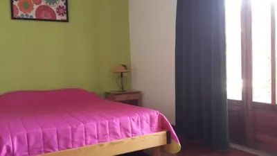 a bedroom with a pink bed and a window at Vila Olímpica in Albufeira