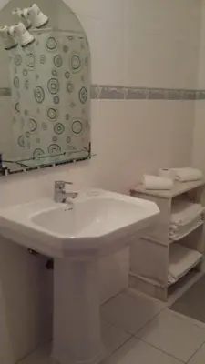 a white bathroom with a sink and a mirror at Vila Olímpica in Albufeira