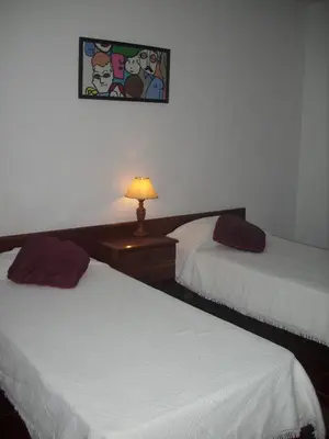 a bedroom with two beds and a lamp on a night stand at Vila Olímpica in Albufeira