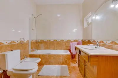 a bathroom with a toilet and a tub and a sink at Vila Caracas - V3 - Vilamoura in Vilamoura