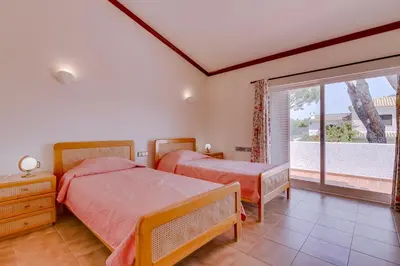 a bedroom with two beds and a window at Vila Caracas - V3 - Vilamoura in Vilamoura