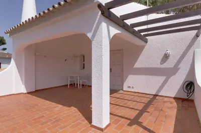 a white house with a patio with a table at Vila Caracas - V3 - Vilamoura in Vilamoura