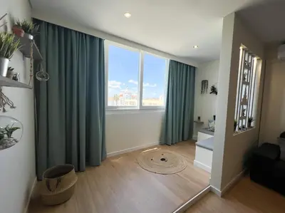 a living room with green curtains and a large window at Sunset Bacara - Near Vilamoura Marina in Vilamoura
