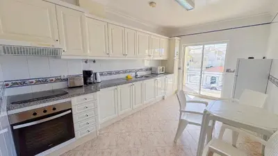 a living room with a table and a dining room at Apartamentos Benvindo by Umbral in Albufeira