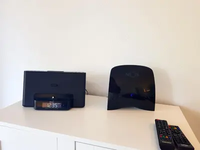 a clock and a box sitting on a counter with two remote controls at Ténis Golf Mar CD 14 - Clever Details in Vilamoura