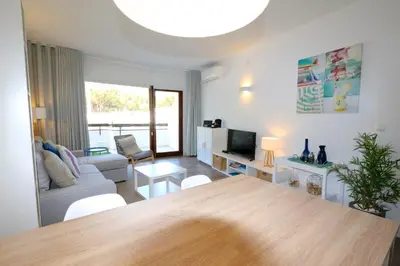 a living room with a table and a couch at Ténis Golf Mar CD 14 - Clever Details in Vilamoura