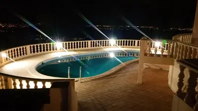 a swimming pool with lights on a balcony at night at Elegant family house in Loulé with private pool in Loulé