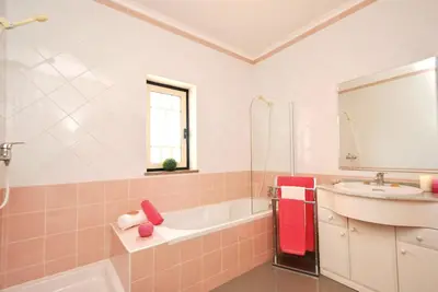 a pink bathroom with a sink and a bath tub at Apartment Ipanema 3 by Algarve Vacation in Albufeira