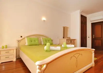 a bedroom with a large bed with green pillows at Villa Nespereira by Algarve Vacation in Albufeira