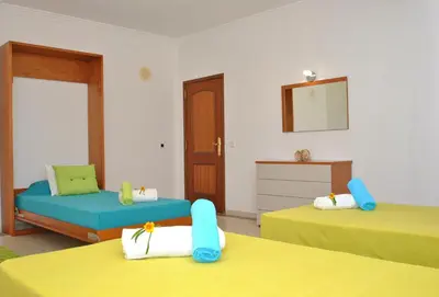 a room with two beds and a chair and a mirror at Villa Nespereira by Algarve Vacation in Albufeira