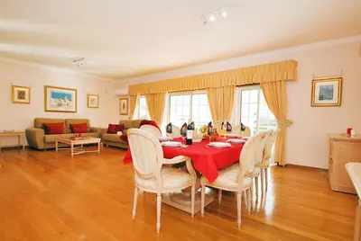 a dining room with a table and chairs and a living room at Villa Nespereira by Algarve Vacation in Albufeira