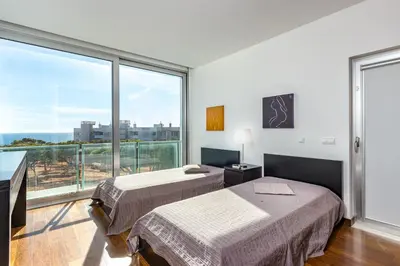 two beds in a room with a large window at Villa Ocean Pine in Albufeira