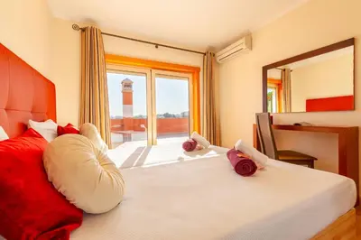 a bedroom with a bed with red pillows and a mirror at Villa California by Algarve Vacation in Albufeira