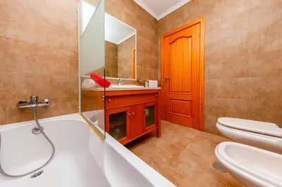 a bathroom with a tub and a sink and a toilet at Villa California by Algarve Vacation in Albufeira