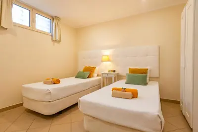 two twin beds in a room with a window at Villa California by Algarve Vacation in Albufeira