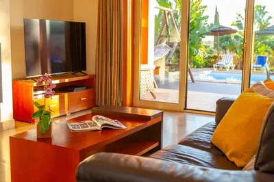 a living room with a couch and a table with a tv at Villa California by Algarve Vacation in Albufeira