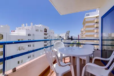 a balcony with a table and chairs on a ship at Mar apartment wonderful view - Quarteira in Quarteira