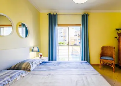 a bedroom with two beds and a large window at BnB Homes Ocean view Apartment with 3 spacious Terraces, 2 Swimming pools & Tennis court in Albufeira