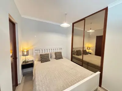 a bedroom with a bed and a mirror at The Marina Plaza Vilamoura in Vilamoura