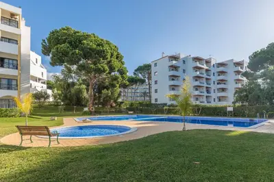 a swimming pool in a park next to a building at Modern Top Floor Apartment 60m2 - Balcony with Pool & Sea View - Vilamoura in Vilamoura