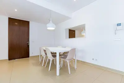 a white dining room with a white table and chairs at Cavalo Preto Luxury Beach Apartment by Golden Zenith in Quarteira