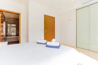a bedroom with a white bed with towels on it at Cavalo Preto Luxury Beach Apartment by Golden Zenith in Quarteira