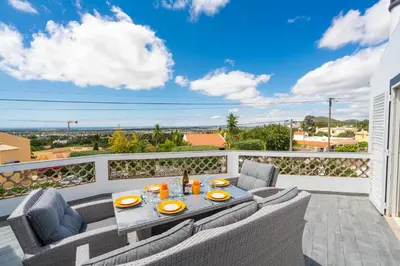 a patio with a table and chairs on a balcony at Casa Laranja Three bedroom Villa in Loulé