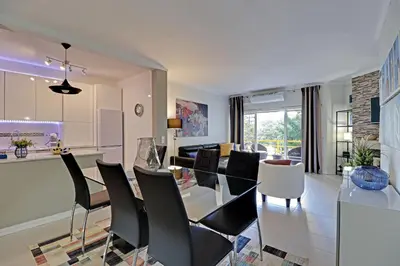 a dining room and living room with a table and chairs at Vilamoura Design 1 with Pool by Homing in Vilamoura