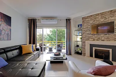 a living room with a couch and a fireplace at Vilamoura Design 1 with Pool by Homing in Vilamoura