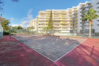 a tennis court in front of a building at Vilamoura Design 1 with Pool by Homing in Vilamoura