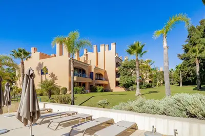 a resort with chairs and umbrellas in front of a building at AL - Apartamento Vila Sol F5 Top Floor in Quarteira
