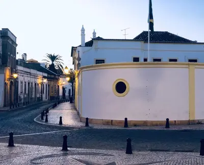 a street with a white building with a circle on it at Baixa de Faro Rooftop in Faro
