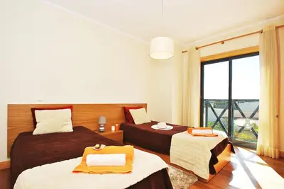 a bedroom with two beds and a large window at Villa Paraty by Algarve Vacation in Albufeira