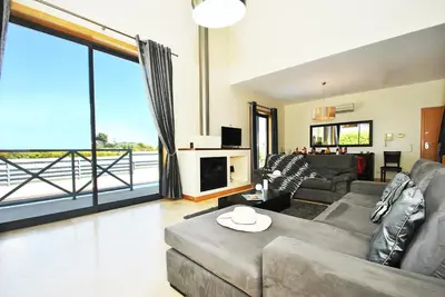a living room with a couch and a large window at Villa Paraty by Algarve Vacation in Albufeira
