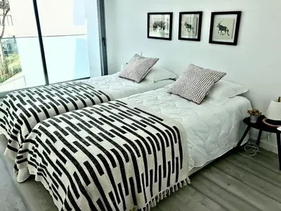 a bedroom with two beds with black and white sheets at Vila Meluna in Albufeira