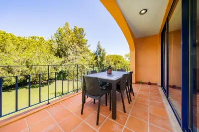 a patio with a table and chairs on a balcony at AL - Apartamentos Vila Sol F5 Bloco 3 in Quarteira