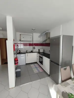 a kitchen with white cabinets and a stainless steel refrigerator at Alsol C 5360 in Quarteira