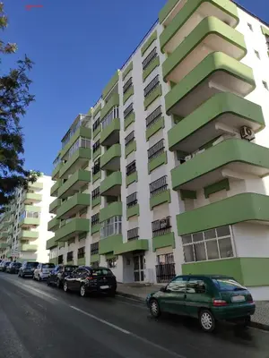 a green and white building with cars parked in front of it at Alsol C 5360 in Quarteira