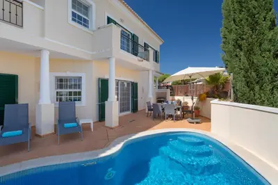 a house with a swimming pool in front of a house at Aleisha in Vale do Lobo