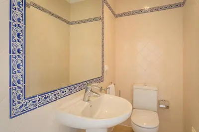a bathroom with a sink and a toilet and a mirror at Aleisha in Vale do Lobo