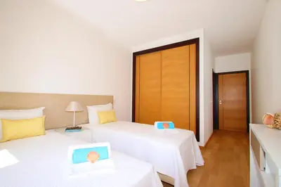 a bedroom with two beds and a wooden door at Apartment Caracas 2 by Algarve Vacation in Albufeira
