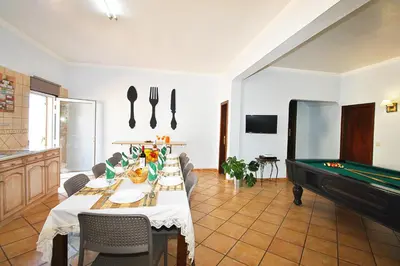 a dining room with a table and a pool table at Villa Zanzibar by Algarve Vacation in Olhos de Água