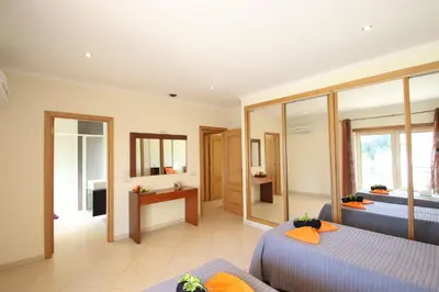 a hotel room with two beds and a mirror at Villa Pauline by Algarve Vacation in Albufeira