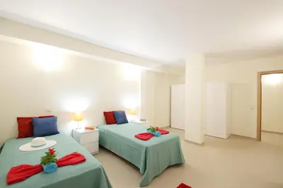 a hotel room with two beds and two tables at Villa Pauline by Algarve Vacation in Albufeira