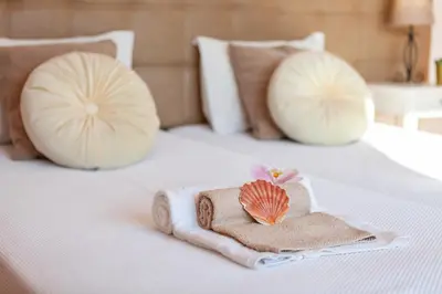 a towel and a seashell on a bed with pillows at Villa Kailua by Algarve Vacation in Albufeira