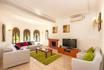 a living room with white furniture and a fireplace at Villa Morais by Algarve Vacation in Guia